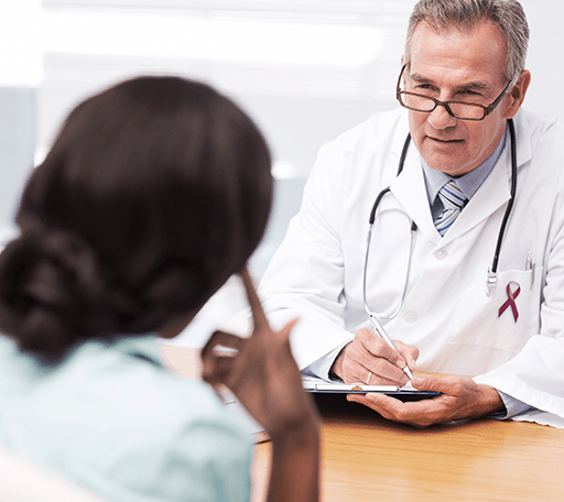 Image of a Healthcare Provider writing on paper, facing a person